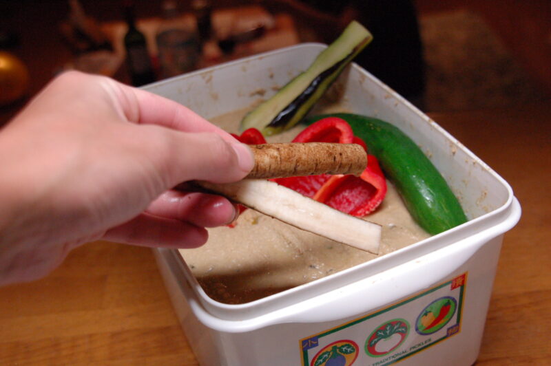 ぬか床へごぼうを入れる